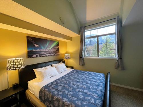 - une chambre avec un lit et une fenêtre dans l'établissement Renovated Chalet at Mystic Springs, Mountain Views, Pets Welcome!, à Canmore