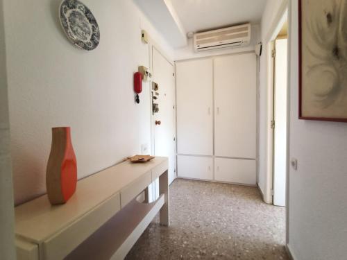 uma sala de estar com uma mesa e um vaso na parede em FIRST LINE SEASIDE - 1 Bedroom BENICASSIM TORREON em Benicàssim