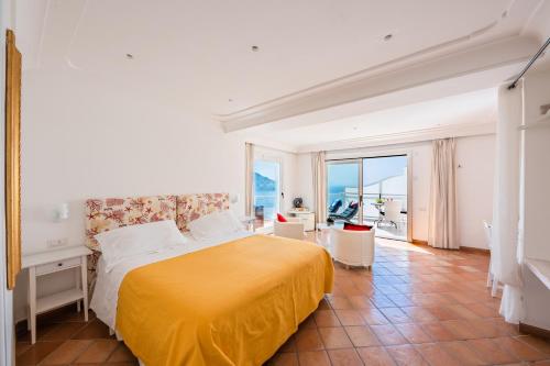 1 dormitorio con cama amarilla y balcón en Villa Anfitrite en Positano