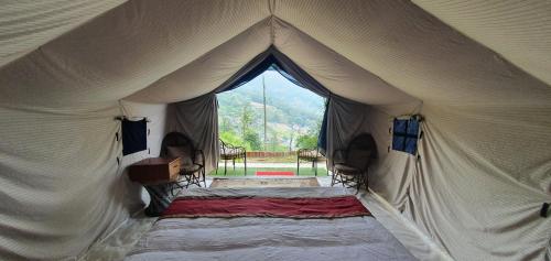 Tienda con cama y ventana en Shivapuri Heights Cottage en Katmandú