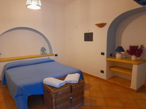 Un dormitorio con una cama con una cesta y una mesa en Casa Mandarino Forio Ischia en Isquia