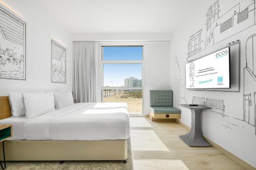 een witte kamer met een bed en een televisie bij Ecos Dubai Hotel at Al Furjan in Dubai