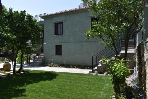 une maison avec une pelouse devant elle dans l'établissement Betty's Garden House, à Nea Anchialos