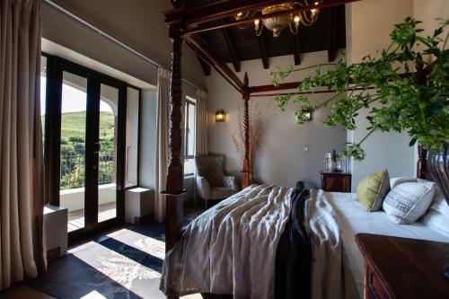 ein Schlafzimmer mit einem Bett und einem großen Fenster in der Unterkunft Mount High Luxury Country Estate in Lydenburg