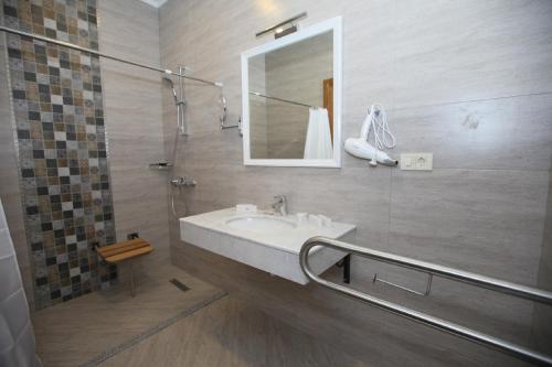 La salle de bains est pourvue d'un lavabo et d'une douche avec un miroir. dans l'établissement Auroom Hotel, à Baku