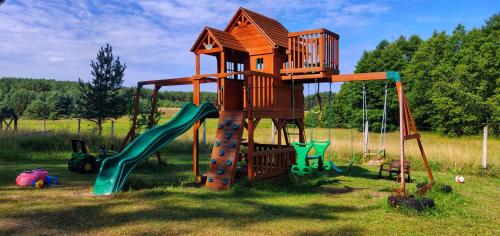 een speeltuin met een boomhut en een glijbaan bij Siedlisko Owink in Swornegacie