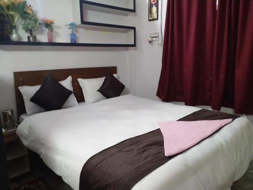 Un dormitorio con una cama con una toalla rosa. en Corporate Guest House en Ranchi