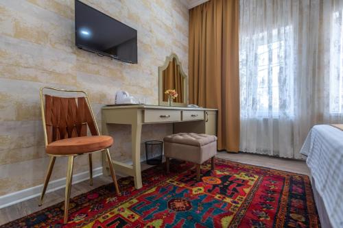 Cette chambre dispose d'un bureau et d'une télévision murale. dans l'établissement NAR BOUTIQUE HOTEL, à Baku