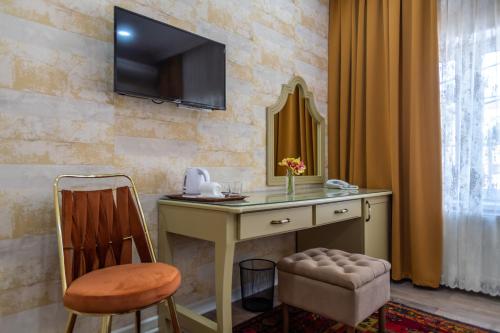 Elle comprend un bureau avec une chaise et une télévision murale. dans l'établissement NAR BOUTIQUE HOTEL, à Baku