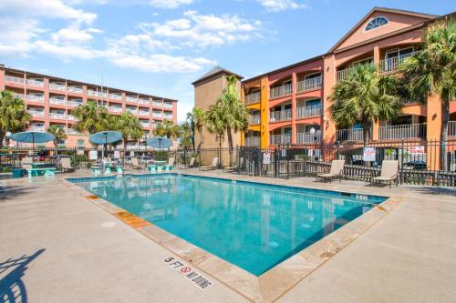 una piscina frente a un hotel en Beachfront Palms Hotel Galveston en Galveston