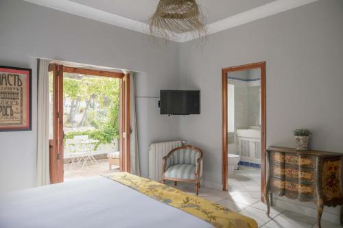 ein Schlafzimmer mit einem Bett, einem Stuhl und einem Fenster in der Unterkunft Villa Dora (Only adults) in Jávea