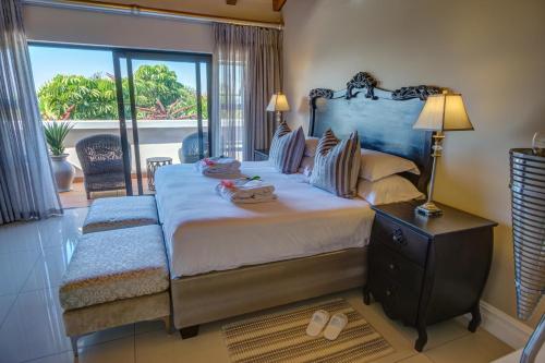 a bedroom with a large bed and a balcony at The View Boutique Hotel & Spa in Amanzimtoti