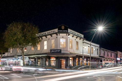 ein Gebäude an der Ecke einer Straße nachts in der Unterkunft The State Hotel in New Plymouth