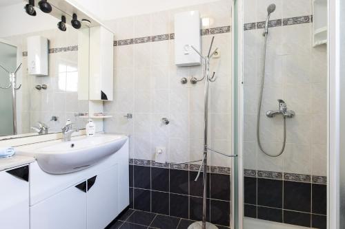 ein Bad mit einem Waschbecken und einer Dusche in der Unterkunft Apartmani Anita in Punat