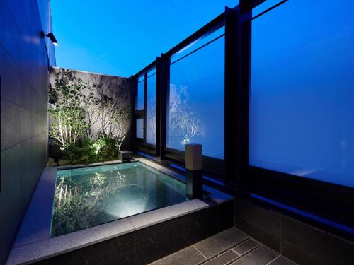 una piscina en el medio de un edificio con ventanas en Susukino Granbell Hotel en Sapporo