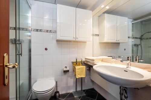 Baño blanco con lavabo y aseo en Ferienwohnung Alastor Travemünde en Travemünde