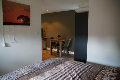 a bedroom with a bed and a table with a chair at Zur Grünen Heide in Wellerlooi