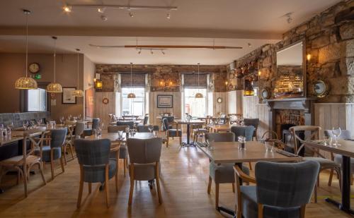 un ristorante con tavoli e sedie in una stanza di Marazion Hotel a Marazion