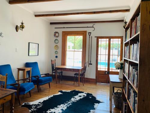 een woonkamer met een tafel en stoelen en een eetkamer bij de Wingerd B & B in Graaff-Reinet