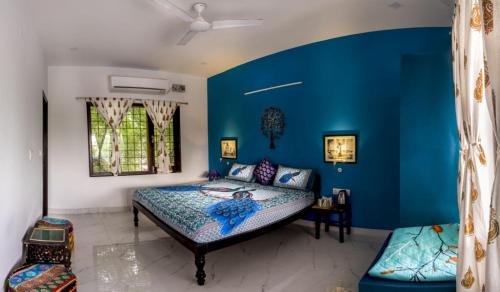 - une chambre avec des murs bleus et un lit dans l'établissement The Coral Tree Boutique Homestay, à Agra