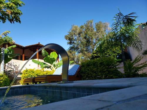 einen Pool mit einer Bank und einem Brunnen in der Unterkunft Recanto Praiana de Búzios in Búzios