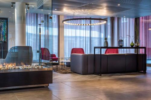 - un hall avec une cheminée et des chaises rouges dans l'établissement Radisson Blu Hotel Tromsø, à Tromsø