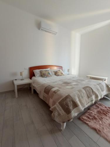 a white bedroom with a large bed and two lamps at CASA DI GIO in Sestri Levante