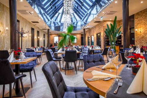 een restaurant met tafels en stoelen en een glazen plafond bij Hotel Diament Plaza Katowice in Katowice