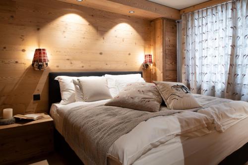 een slaapkamer met een groot bed en een houten muur bij Residenz by Meierhof in Davos