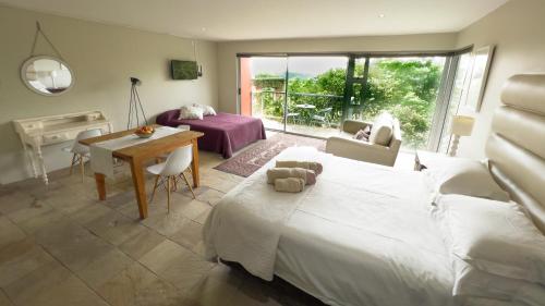 - une chambre avec un lit, une table et un bureau dans l'établissement Orangerie Guest House, à Johannesbourg