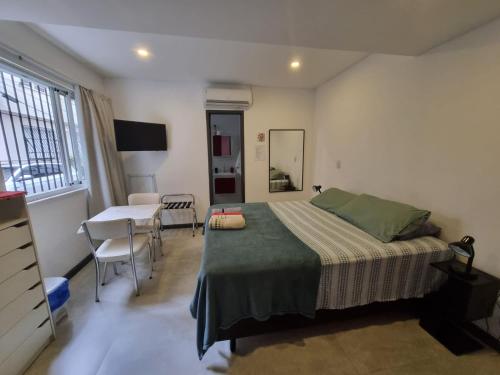 een slaapkamer met een bed, een tafel en een bureau bij Suítes/Studios Privados Copacabana in Rio de Janeiro