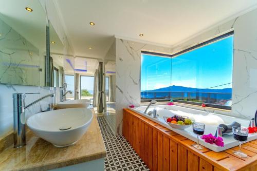 a bathroom with two sinks and a large window at Kalkan Halal villa in Kas