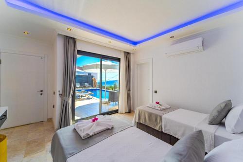 a bedroom with two beds and a view of a pool at Kalkan Halal villa in Kas