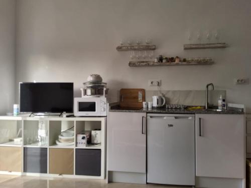 een keuken met witte kasten en een magnetron bij Tranquility studio apartment in Málaga