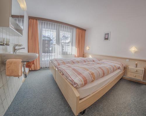 una camera con letto, lavandino e finestra di Apartments Bergrose a Saas-Fee