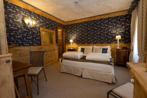 um quarto com 2 camas num quarto com papel de parede azul em Hotel Bucaneve em Breuil-Cervinia