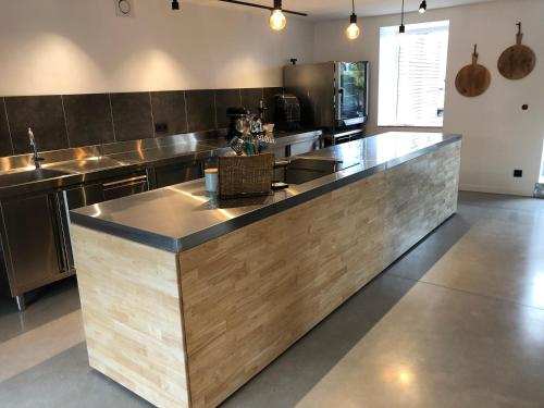 una gran cocina con una gran encimera de madera en L’idée du jour en Onhaye