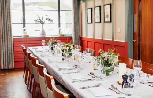 einen langen Tisch in einem Restaurant mit Blumen darauf in der Unterkunft The High Field Town House in Birmingham