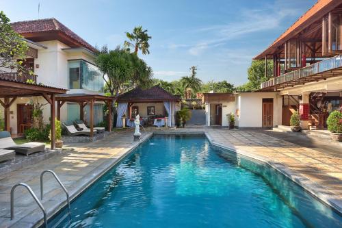 - une piscine en face d'une maison dans l'établissement Respati Beach Hotel, à anur