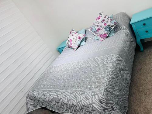 Una cama con dos almohadas encima. en Departamento a metros de playa en Los Molles