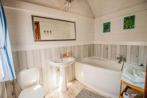 uma casa de banho com uma banheira, um lavatório e um WC. em Holiday House Folwark Jeleń em Poniklica