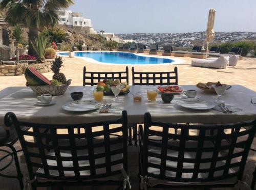 een tafel met eten en drinken op de patio bij Navy Blue Suites in Ornos