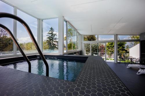 una piscina en una casa con ventanas en Villa Bauhaus Penthouse Wellness Apartman, en Siófok