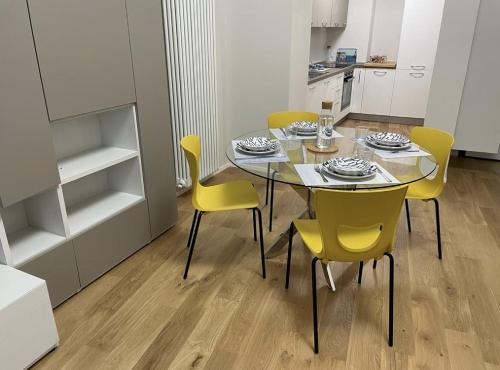 a dining room with a table and yellow chairs at Pellicceria Guest House in Genova