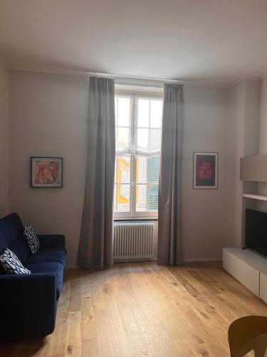 a living room with a blue couch and a window at Pellicceria Guest House in Genova