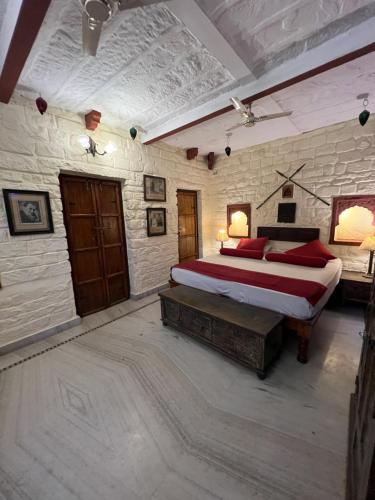 een slaapkamer met een bed en een stenen muur bij Juna Mahal Boutique Home Stay in Jodhpur