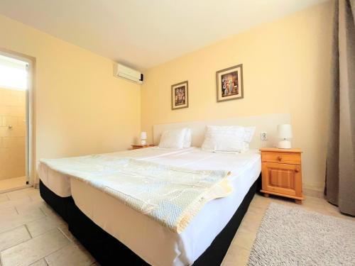 um quarto com uma grande cama branca e uma mesa de cabeceira em Lotus Family Hotel - Free Parking em Sunny Beach