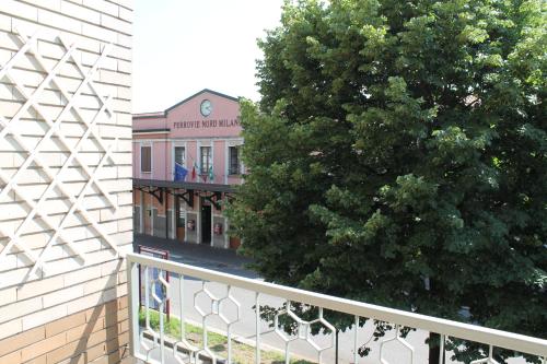 un edificio con un albero accanto a una recinzione di L'appartamento della Stazione di Saronno a Saronno