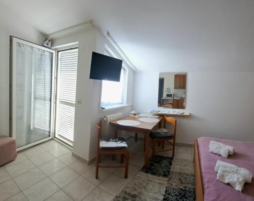 mały salon ze stołem i łóżkiem w obiekcie Studio apartman Olivera w Rovinj