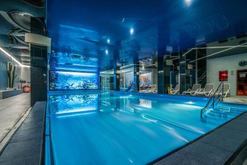 una piscina con iluminación azul en un edificio en Hotel SPA Faltom Gdynia Rumia en Rumia